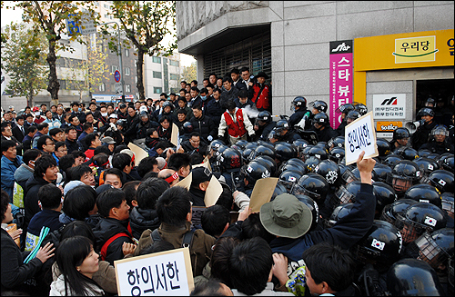 열린우리당 부산시당 진입을 시도하는 노동자들에게 소화기를 뿌리고 있는 경찰 